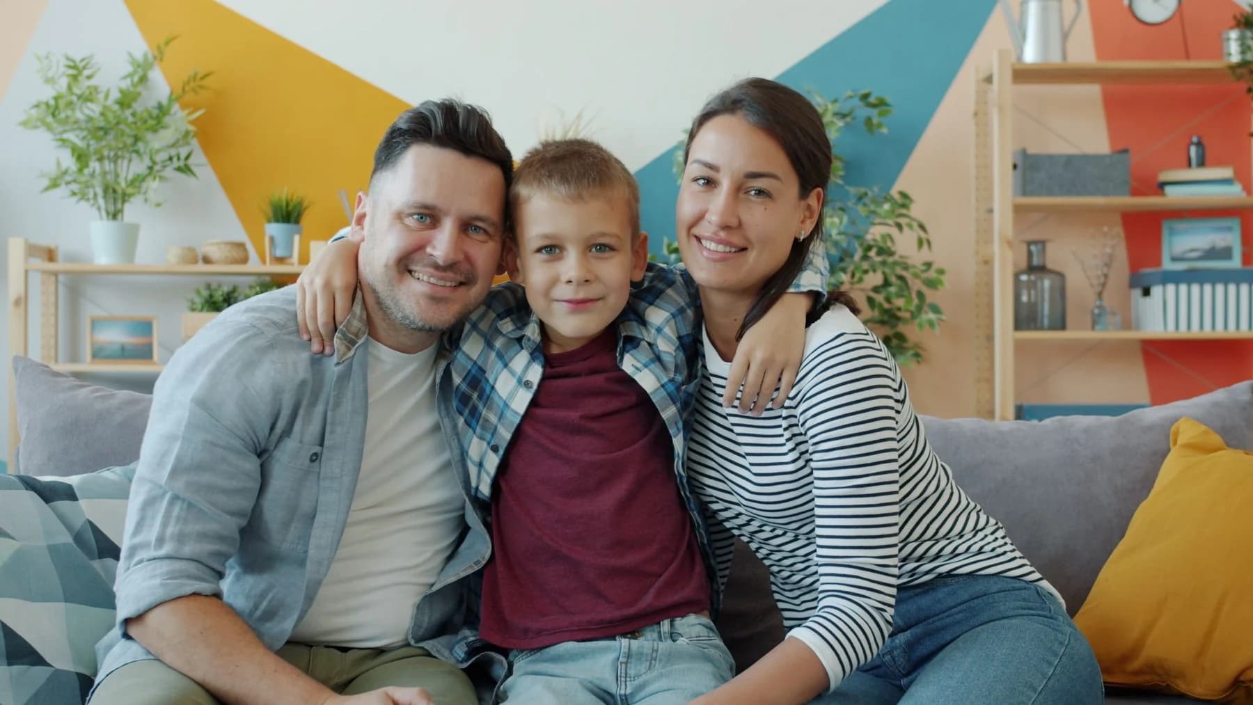 Family of three sitting together in a colorful living room