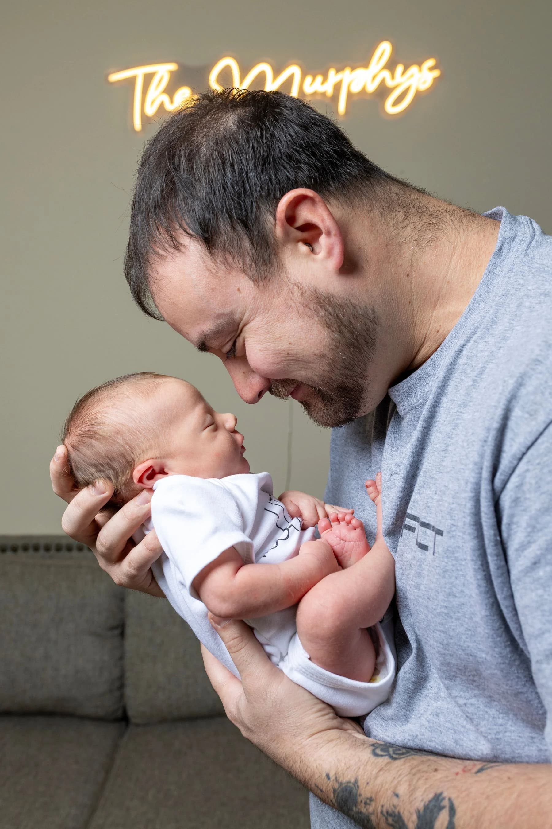 Father holding a newborn baby indoors at home